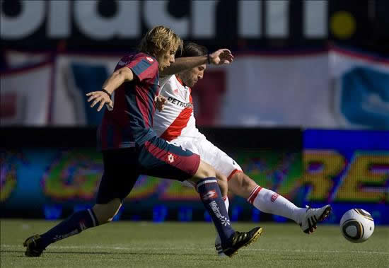 Jonathan Bottinelli (i) de San Lorenzo disputa el balón con Mariano Pavone (d) de River Plate. Foto: EFE