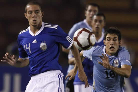 El jugador de Argentina Claudio Mosca (i) busca el balón ante la marca de Pablo Cepelini. Foto: EFE