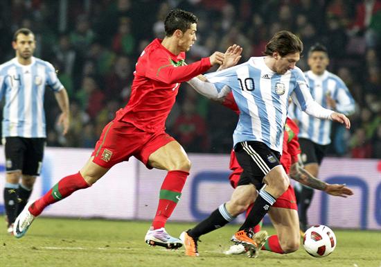 El jugador Lionel Messi (c) de Argentina lucha por el balón con Cristiano Ronaldo. Foto: EFE