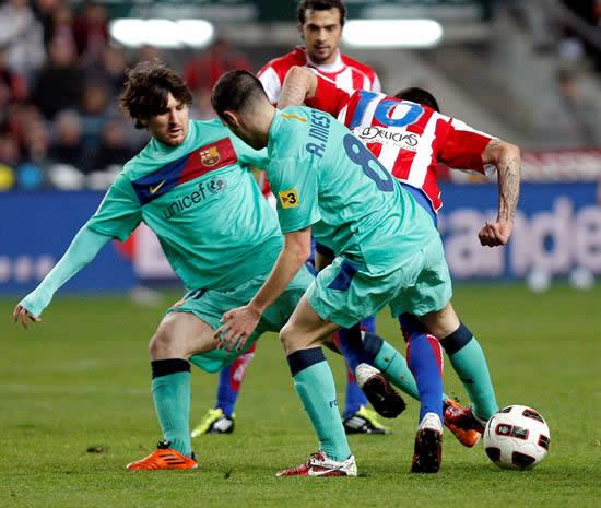 El argentino del FC Barcelona Lionel Messi (i) y su compañero Andrés Iniesta (d) luchan con el delantero del Sporting Nacho Novo. Foto: EFE