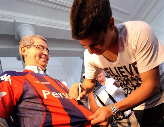 El joven delantero argentino Juan Iturbe firma autógrafos tras reunirse con el presidente paraguayo, Fernando Lugo. Foto: EFE