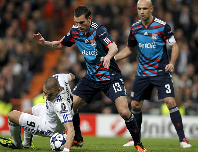 Karim Benzema (i), pelea un balón con los defensas de Lyon. Foto: EFE