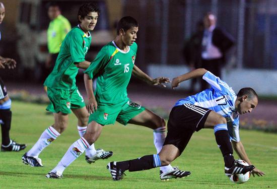 El jugador de la selección de Argentina, Agustín Allione (d), disputa el balón con José Sagredo (c) de Bolivia. Foto: EFE