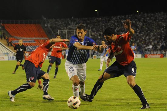 El jugador de Independiente de Avellaneda Eduardo Tuzzio (d) disputa el balón con Nicolás Sánchez (c) de Godoy Cruz. Foto: EFE