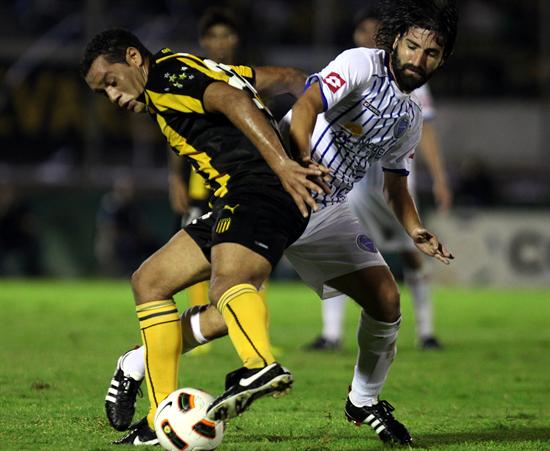 El jugador de Godoy Cruz de Argentina, Diego Villar (d), disputa el balón con Darío Rodríguez (i), de Peñarol. Foto: EFE