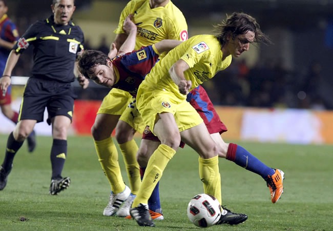 El delantero argentino del FC Barcelona, Leo Messi (i), pelea por el balón con el defensa argentino del Villarreal, Gonzalo Rodriguez. Foto: EFE