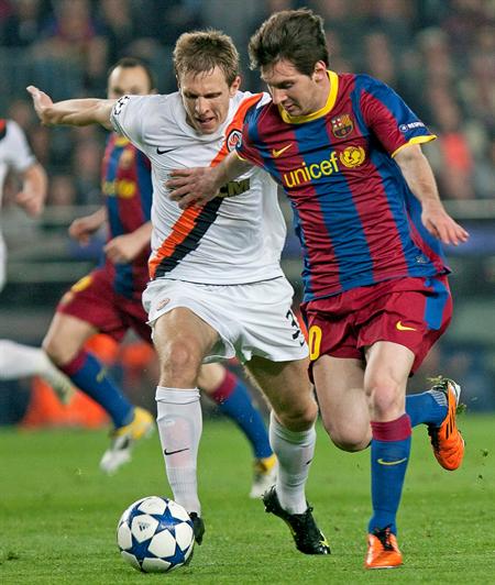 Lionel Messi (d) avanza con el balón perseguido por el defensa del Shakthar Donetsk Mykola Ishchenko. Foto: EFE