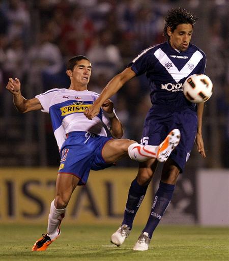 El jugador de Universidad Católica Santiago Dittborn (i) lucha por el balón con Ezequiel Rescaldani (d) de Vélez. Foto: EFE