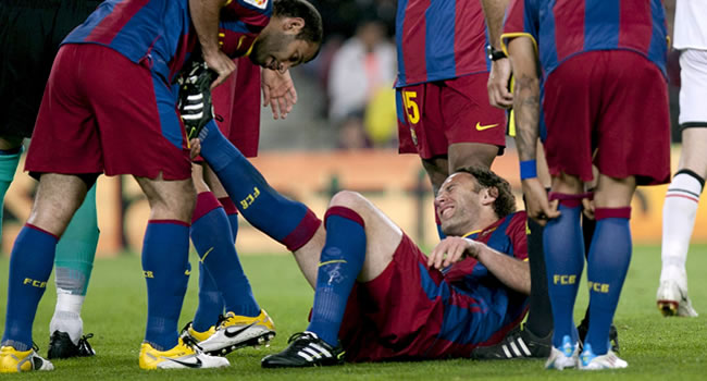El defensa argentino del FC Barcelona Gabriel Milito (c) permanece en el suelo tras lesionarse. Foto: EFE