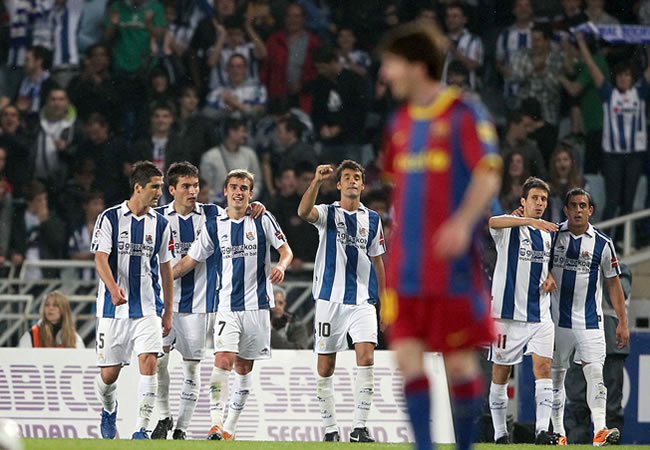 Los jugadores de la Real Sociedad celebran ante Leo Messi. Foto: EFE
