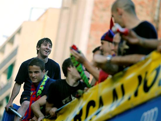 El jugador argentino del FC Barcelona, Leo Messi (i), rie sentado, en el autobús descubierto con el que celebra la plantilla azulgrana. Foto: EFE