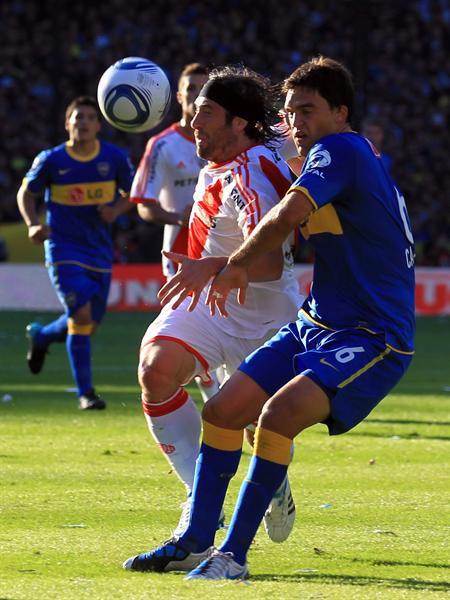 El jugador de River Plate Mariano Pavone (i) disputa el balón con Matías Caruzzo (d), de Boca Juniors. Foto: EFE