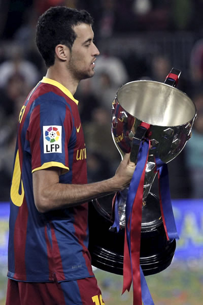 El centrocampista del FC Barcelona Sergio Busquets sujeta el trofeo de campeón de Liga. Foto: EFE