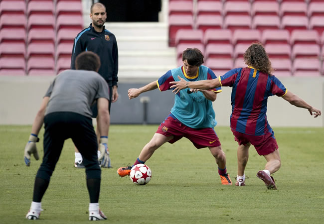 El técnico del FC Barcelona, Josep Guardiola (detrás), observa a los jugadores Oier (i), Lionel Messi (c) y Carles Puyol, durante el entrenamiento. Foto: EFE
