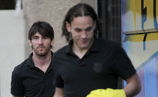 Messi, delantero del FC Barcelona, tras Gabriel Milito, que ha recibido el alta médica. Foto: EFE