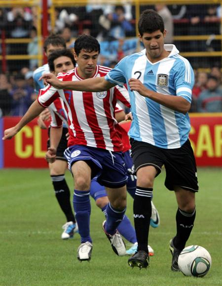 El jugador de la selección argentina Lizandro Lopez (d) disputa el balón con Julián Benítez (i) de Paraguay. Foto: EFE