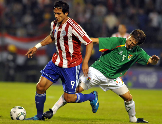 El jugador de la selección paraguaya, Roque Santa Cruz (i) disputa el balón con Cristhian Vargas (d) de Bolivia. Foto: EFE