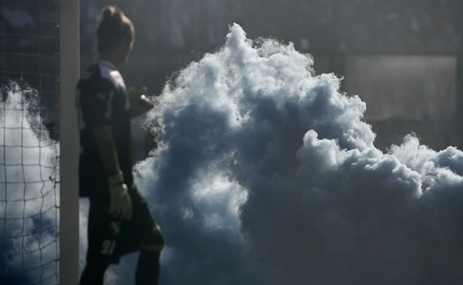 El arquero de Independiente, Fabián Assman, observa la nube de humo en el clásico de Avellaneda. Foto: EFE