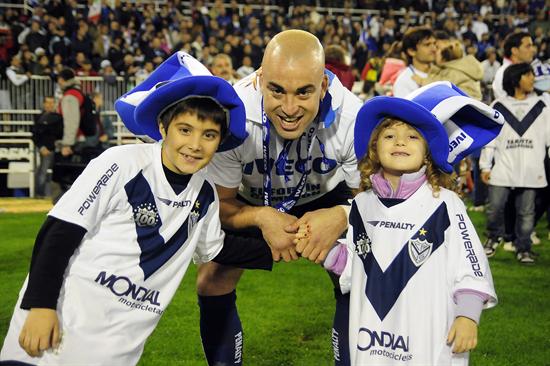 El jugador del club Vélez Sarsfield Santiago Silva (c) festeja con dos niños. Foto: EFE