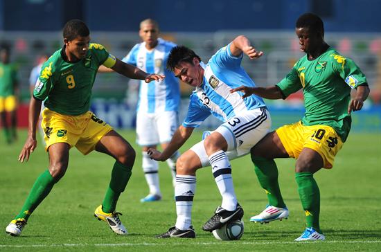 El jugador de la selección Argentina de fútbol Maximiliano Padilla (c) lucha por el balón con Omar Holness (i) y Jason Wrigt (r) de Jamaica. Foto: EFE