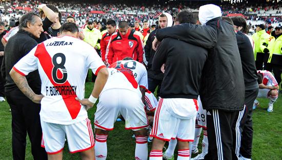 El DT de River Plate Juan José López (i), Fabián Bordagaray (c) y Eric Lamela (d), se lamentan junto a sus compañeros su descenso. Foto: EFE