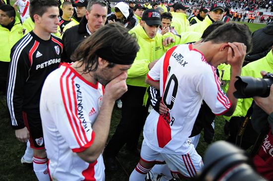 Los jugadores Mariano Pavone (i) y Eric Lamela (d) de River Plate se lamentan junto a sus compañeros el descenso. Foto: EFE