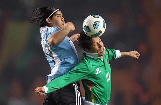 El argentino Ever Banega (Iz) y el boliviano Joselito Vacas saltan por el balón. Foto: EFE