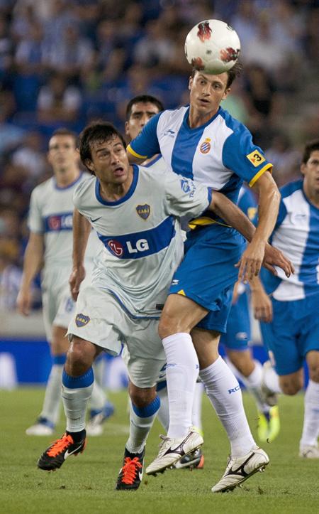 El defensa del RCD Espanyol Ernesto Galán (d) pelea un balón con el delantero de Boca Juniors Dario Cvitanich. Foto: EFE