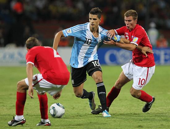 El jugador de la selección de Argentina Erik Lamela (c) disputa un balón con Blair Adams (i) y Callum MacManaman (d) de Inglaterra. Foto: EFE