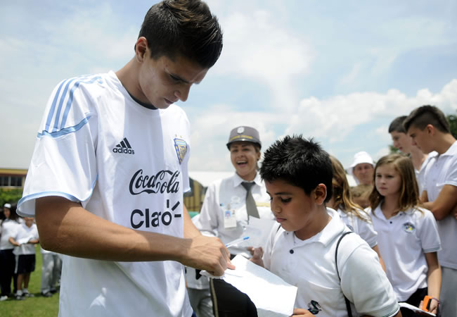 El jugador de la selección sub 20 de Argentina Erik Lamela (i) firma autógrafos a los niños en Colombia. Foto: EFE