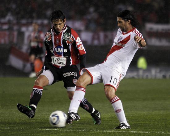 El jugador del River Plate Alejandro Domínguez (d) y Ángel Piz (i) de Chacarita Juniors luchan por el balón. Foto: EFE