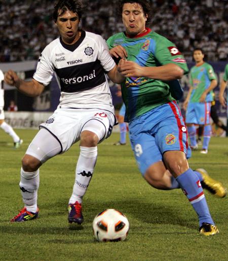 El jugador de Arsenal de Argentina Nicolás Aguirre (d) disputa el balón con Pablo Zeballos (i) del Olimpia. Foto: EFE