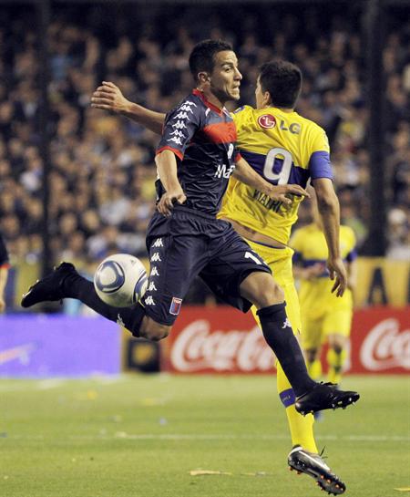 Lucas Viatri (d) de Boca Juniors disputa el balón con Carlos Casteglione de Tigre. Foto: EFE