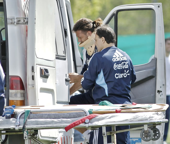 El defensor Martín Demichelis es llevado a una ambulancia tras chocar con Marcos Rojo al finalizar la práctica de Argentina. Foto: EFE