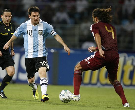 El jugador argentino Lionel Messi (i) disputa el balón con el venezolano Oswaldo Vizcarrondo. Foto: EFE