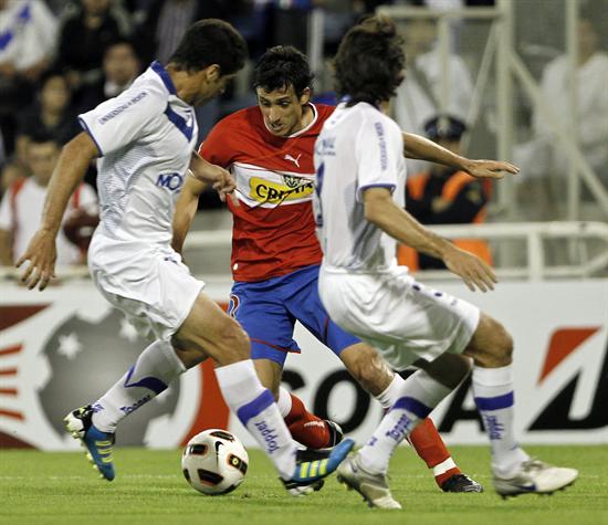 El jugador de la Universidad Católica de Chile Milovan Mirosevic (c) controla el balón ante la marca de Sebastián Domínguez (i) y Emiliano Papa (d) de Vélez. Foto: EFE