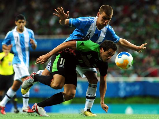 El mexicano Geronimo Amione (abajo) disputa el balón con el argentino Leandro González. Foto: EFE