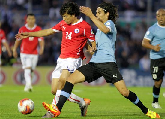 El jugador uruguayo Edinson Cavani (d) disputa el balón con el chileno Matías Fernández. Foto: EFE