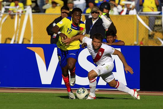 El jugador ecuatoriano Jaime Ayoví (i) disputa el balón con el peruano Renzo Revoredo. Foto: EFE