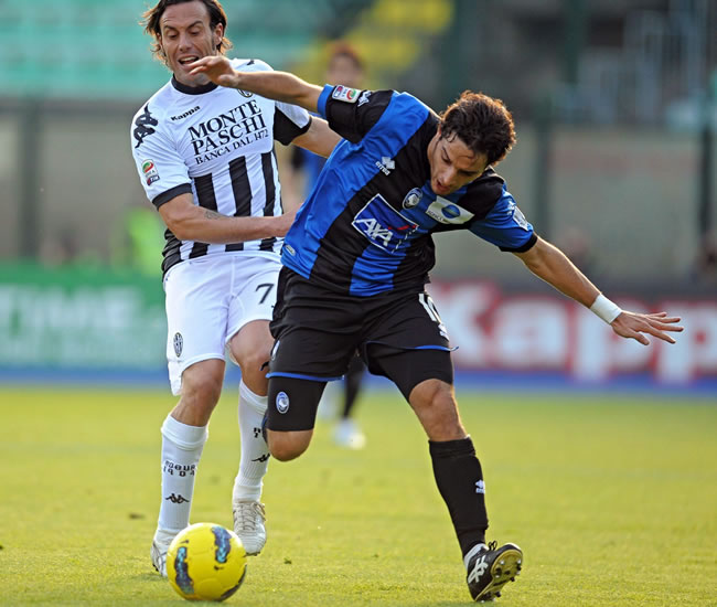 El delantero argentino del Atalanta, Germán Gustavo Denis (dcha), pelea por el control del balón con el jugador del Siena. Foto: EFE