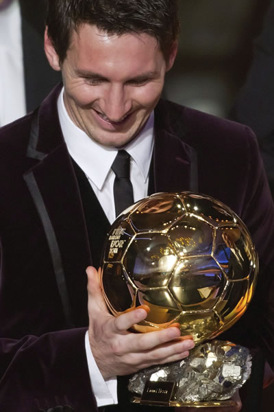 El argentino del FC Barcelona Lionel Messi observa el galardón de mejor jugador del 2011. Foto: EFE