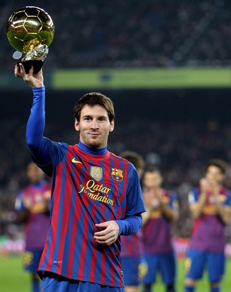 El delantero argentino del FC Barcelona Leo Messi ofrece el trofeo del Balón de Oro. Foto: EFE