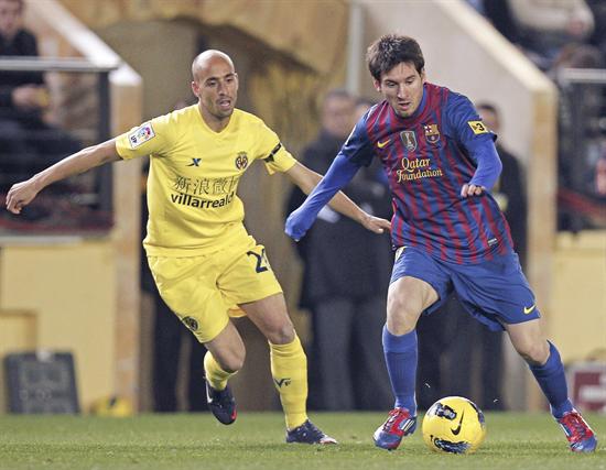 El delantero argentino del FC Barcelona Lionel Messi (d) conduce el balón presionado por el mediocentro del Villarreal. Foto: EFE