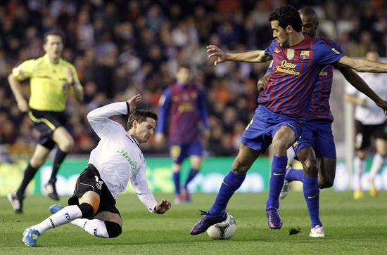 El delantero argentino del Valencia Pablo Piatti (i) intenta robar el balón al centrocampista del Barcelona Sergio Busquets. Foto: EFE