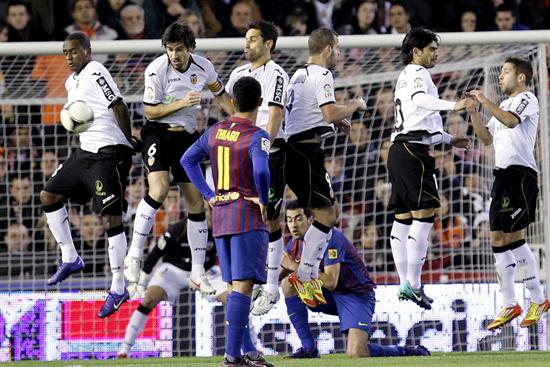 El centrocampista del Barcelona Thiago Alcantara (en primer plano), observa como salta la barrera del Valencia. Foto: EFE