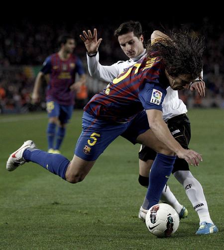 El defensa del FC Barcelona Carles Puyol (i) lucha por el balón con el delantero argentino del Valencia CF Pablo Piatti. Foto: EFE