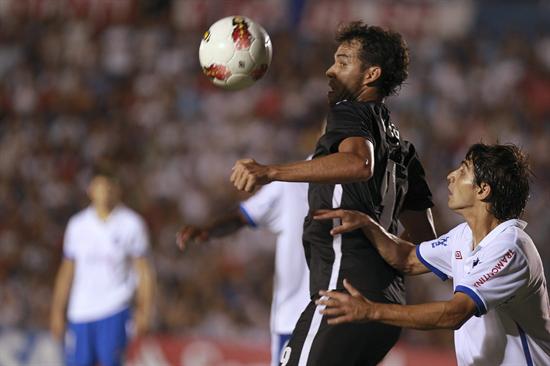 l jugador de Libertad, Pablo Velázquez (i), disputa el balón con Mauricio Calzada (d) de Nacional. Foto: EFE