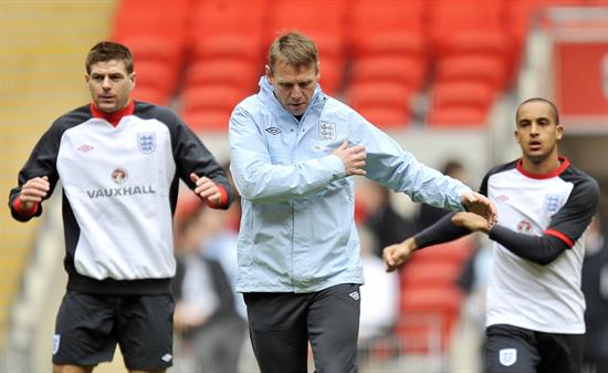 El seleccionador provisional de Inglaterra, Stuart Pierce (c), realiza ejercicios de calentamiento junto a Steven Gerrard (i) y Theo Walcott. Foto: EFE