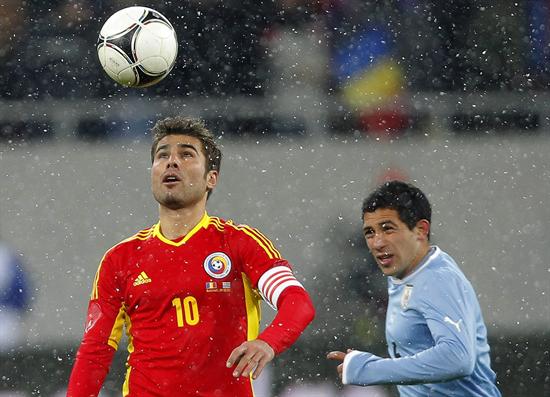 El jugador Walter Gargano (d) de Uruguay disputa un balón con Adrian Mutu de Rumanía. Foto: EFE
