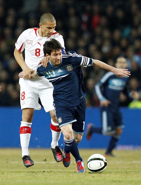 El delantero de la selección argentina de fúibol Lionel Messi (d) lucha por el balón con el suizo Goekhan Inler. Foto: EFE